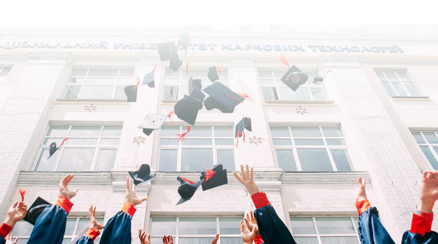 A group of students throwing graduation caps in air